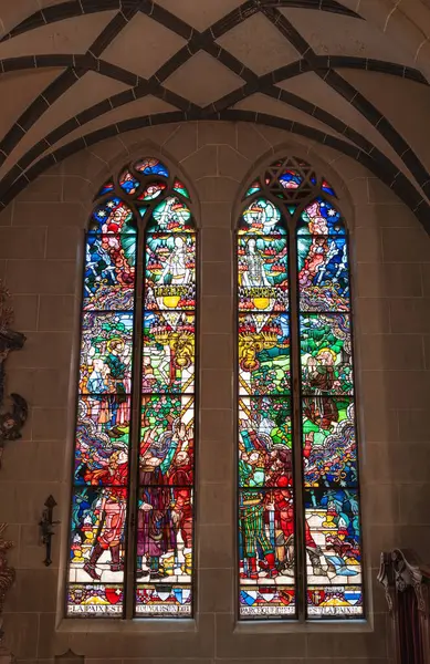 Fribourg, İsviçre - 2 Temmuz 2024: Fribourg katedralindeki renkli vitray pencereler dini sahneleri resmediyor.