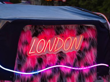 Kürklü, pembe ve siyah arkaplanda neon işareti var..