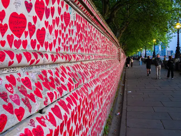 Londra, Birleşik Krallık - 28 Nisan 2025: COVID-19 salgını sırasında ölen insanların anısına kırmızı kalplerle kaplı bir duvar - Ulusal COVID Anma Duvarı.