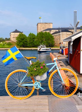 Stockholm şehrinin ufuk çizgisi üzerinde çarpıcı bir günbatımı, tarihi ve modern mimarinin bir karışımı. Güneş büyük ve turuncu..