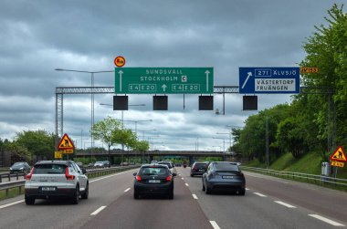 Alvsjo, İsveç - 6 Haziran 2025: Sundsvall ve Stockholm yönlerini gösteren trafik işaretleriyle dolu yoğun bir otoyol sahnesi.