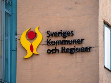 Stockholm, İsveç - 4 Haziran 2025: Toplumu veya bağlantıyı sembolize eden bir logonun bulunduğu binanın ön yüzü. Metinde Sveriges Kommuner och Regioner yazıyor..