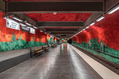 Stockholm, İsveç - 9 Haziran 2025 Stockholm 'de çarpıcı turuncu ve yeşil kaya duvarlı boş Solna merkez metro istasyonu.