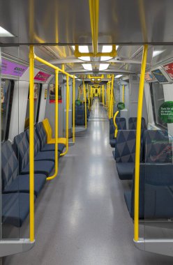 Stockholm, İsveç - 9 Haziran 2025: Stockholm 'de içi boş, modern bir metro treni manzarası, sarı direkler ve desenli koltuklar, temiz ve ferah bir ortam sergiliyor..