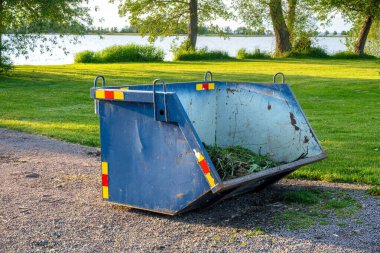 Renkli bayraklar ve mavi bir işaretle Interlaken Ost tren istasyonunun canlı bir görüntüsü. Binanın çiçek kutularıyla büyüleyici bir mimari tarzı var..