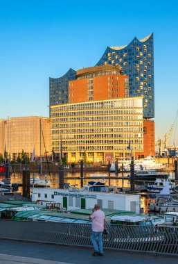 Hamburg, Almanya - 1 Temmuz 2025: Modern liman binaları, Elbphilharmonie konser salonu, eşsiz mimari tasarımı, tekneler ve suyla çevrili.