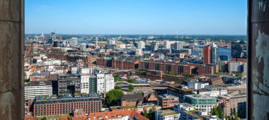  Tabakların ve bardakların bulunduğu ahşap bir vitrin ve salata istasyonu ilan eden karatahta levhası. Taze yeşiller arka planda görünür..