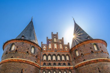  Tabakların ve bardakların bulunduğu ahşap bir vitrin ve salata istasyonu ilan eden karatahta levhası. Taze yeşiller arka planda görünür..