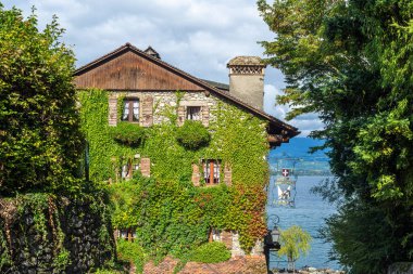 Yvoire, Fransa - 25 Eylül 2025: Cenevre Gölü kıyısındaki Ortaçağ Fransız kasabası Yvoire 'de bulunan sarmaşık kaplı otel restoranı