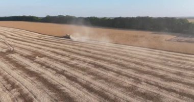 Tarım çiftliği makineleri. Kırsal çayırlarda çalışan tarımsal ekipmanların havadan görünüşü. Kırsal kesimlerde hasat makinası sürüyor.