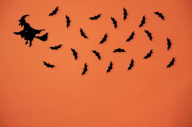 Bir cadının tahta kesimleri ve turuncu bir arka planda izole edilmiş yarasalar..