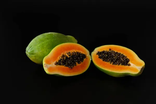 Papaya meyvesi, siyah arka planda yarı izole bir şekilde kesilmiş..