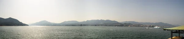 Beautiful panoramic landscape of Miyajima city with ferry boat from the island in Hiroshima prefecture, Japan.