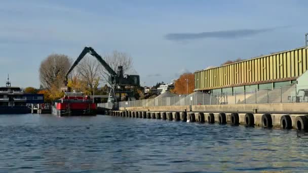 港のクレーン 石の山から赤いボートに小石を扱うことによって働く大きな掘削機 建設現場の作業機械 — ストック動画
