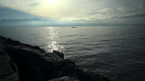 水上のボートチームの背後にある朝の太陽 湖ジュネーヴ 空と雲の風景 リアルタイムだ ローザンヌヴォーカントンスイス — ストック動画