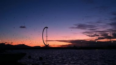 Sunset over lake. Flock of birds flying in the sky over lake Geneva and mountain. Port of Ouchy, Lausanne, Vaud Canton, Switzerland. Beauty in nature.