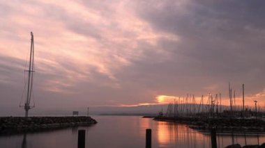 Gölün üzerinde gün batımı. Cenevre Gölü manzarası, Dağ ve Ouchy rıhtım heykeli. Ouchy Limanı, Lozan, Vaud Canton, İsviçre. Gündüzden geceye zaman aşımı.
