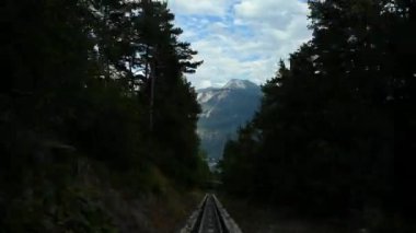 Crans Montana 'dan Sierre, Valais Canton, İsviçre' ye kadar kırmızı İsviçre füniküleri aşırı kaymış. Şehir ve dağ manzaralı toplu taşıma tramvayı.