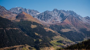 Sonbaharda dağların, gökyüzünün ve ormanın manzarası. Liddes, Valais Canton, İsviçre.