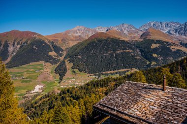 Sonbaharda dağ, baca ve taş kiremit çatı. Liddes, Valais Canton, İsviçre.