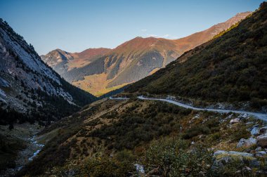 Sonbaharda dağların, gökyüzünün, ormanın ve patikanın manzarası. Liddes, Valais Canton, İsviçre.