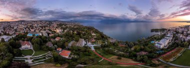 Lozan şehrinin havadan görünüşü. Gün batımında liman ve gökyüzü manzarası. Ouchy, Vaud Canton, İsviçre.