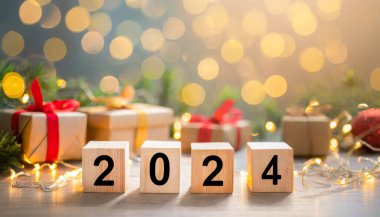Odaklanmamış ışıkları olan bir yığın tahta küp. 2024 yeni yıl konsepti. İş konsepti. Arkaplan.