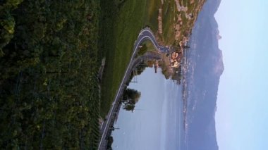 Dağlar, üzüm bağları ve göl manzarası. Gün batımında Lavaux üzüm bağının, trafiğin, binaların ve Cenevre Gölü 'nün zaman aşımı.