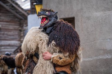 Reveller tahta maske ve karnaval kostümü giyiyor. Evolene, Valais Canton, İsviçre.