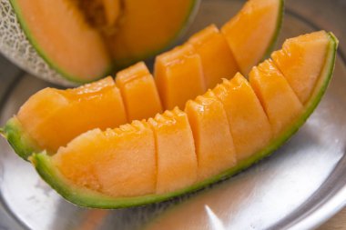 Portakal karpuzunu ahşap tabakta bölmek için yakın plan.