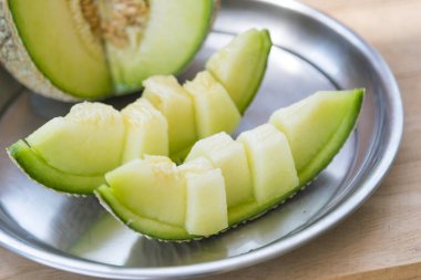 Tabakta bir sürü taze yeşil kavun var.