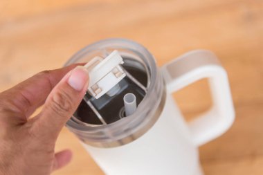 Ahşap masanın üzerinde beyaz bir el arabası var.   