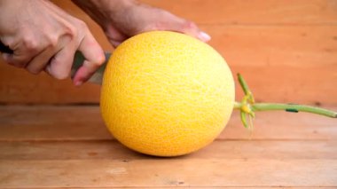 Ahşap tabakta sarı karpuzu ikiye böl.