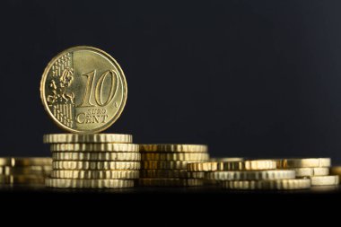 Koyu bir arkaplanda diğer avro paralarının üzerine tünemiş 10 avro sent