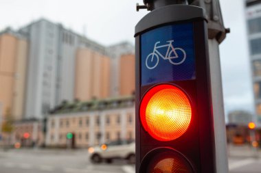 Bisikletler için kırmızı bir trafik ışığının fotoğrafı, bir şehirde yakından görülüyor.