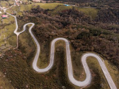 Cantabria, İspanya 'daki El Soplao mağarasına giden yolun havadan görünüşü. Drone görüşü. Keskin kıvrımlı dağ yolu.