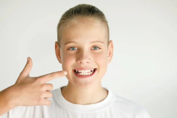 The child smiles and points to his teeth. Dental medicine and healthcare