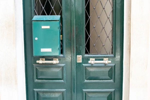 Street old green dusty door with mailbox