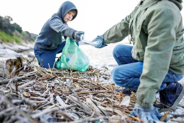 Children volunteers clean up garbage and plastic outdoors - ecology concept. selective focus