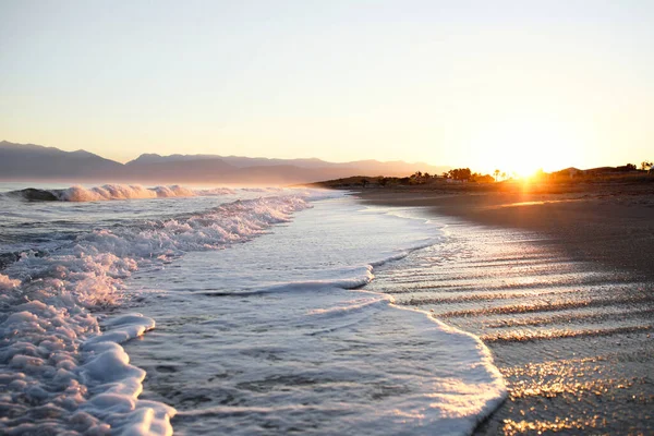 Beautiful sunrise, purple-pink haze over the sea with a view of the mountains