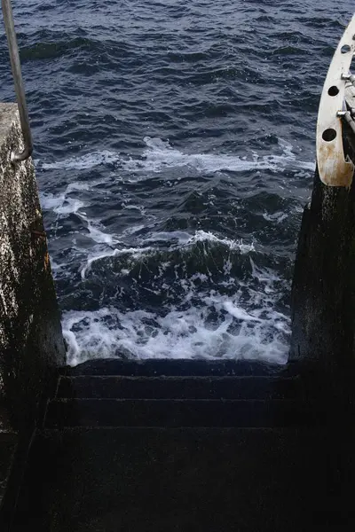 Taştan bir iskelede deniz dalgası