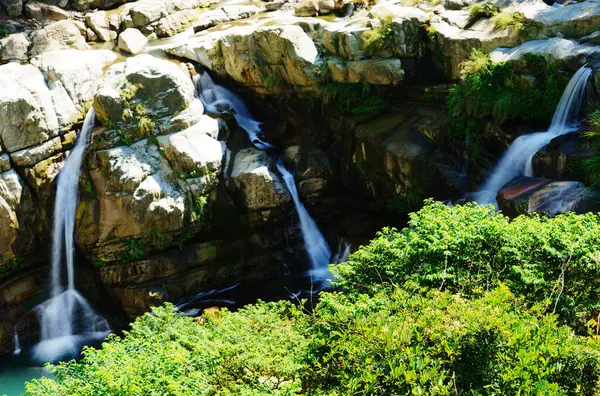 Kaya duvarının çatlaklığından çoklu şelale