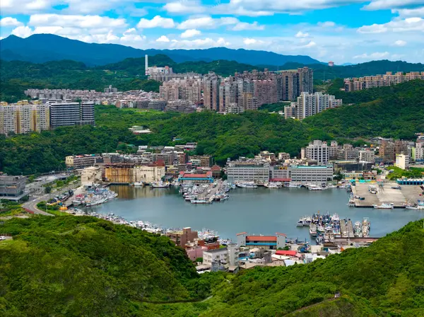 Dağlarda yer alan ve limanı çevreleyen binalar.