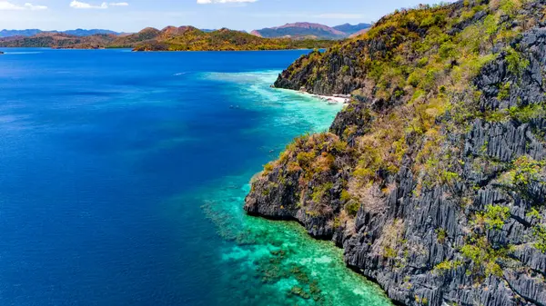 Gök mavisi, berrak deniz ve güzel kayalık kıyı şeridi.