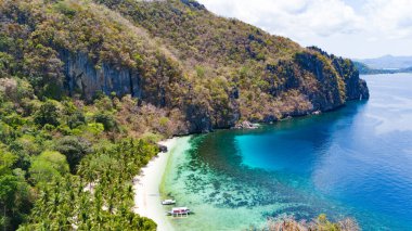 Sakin, berrak sığlıklar ve beyaz kumlu plaj.