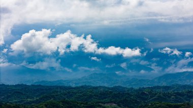 Uzak sıradağlar ince bulutlar ve sisle örtülüdür.