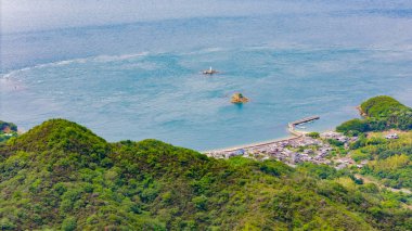 Huzurlu bir körfezle kurulmuş bir sahil köyü. Uzak adacıklar ve bir deniz feneri Sakin denizi noktalar.