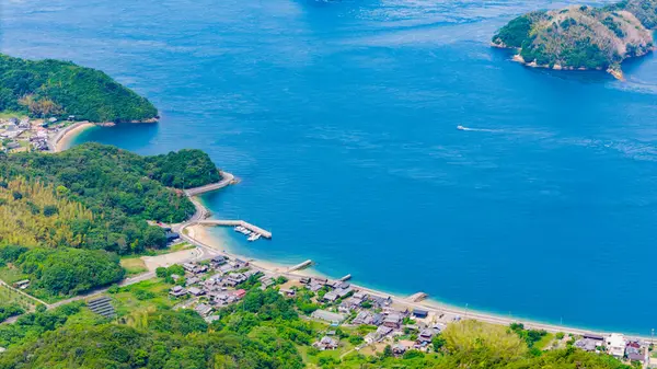 Huzurlu bir körfezin manzarası yükseldi. Bereketli bir arazi büyüleyici bir deniz kenarı yerleşimiyle buluşur.