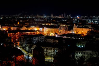 Kyiv, Ukraine - January 10, 2022: Night view of the city center. A bird's eye view of the Podil district in Kyiv. Ferris wheel. Peaceful New Year's Kyiv.