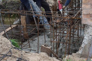 Beton bir pompa kullanarak temeli betonla dökerek.